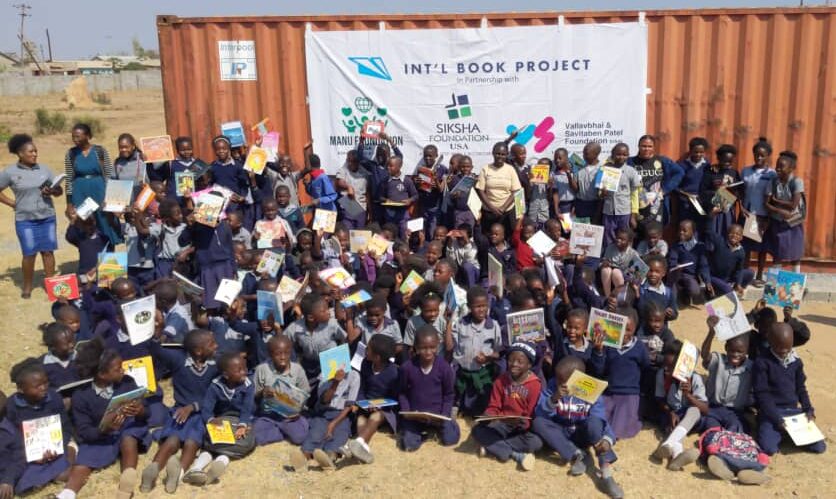 children from kapoto primary school in zambia gather in front of a shipping container that delivered them and many other schools in the region new books